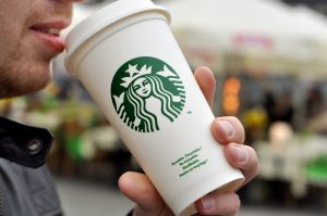 man holding Starbucks coffee cup