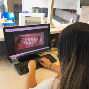 Girl typing and looking on Teeth in Desktop