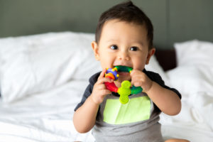 cute baby boy sitting and playing with toy