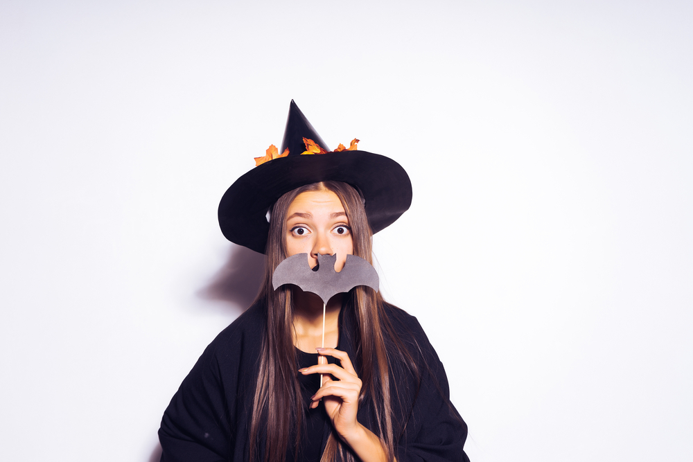 Young girl posing in a witch costume for halloween