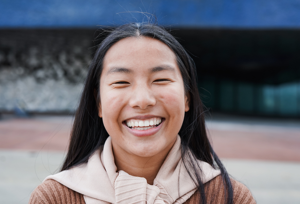 Happy young asian woman smiling on camera